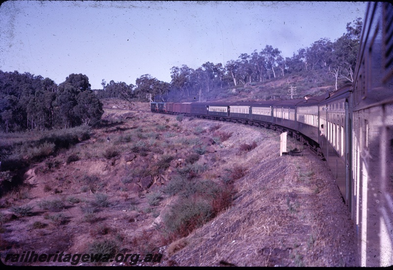 T04365
Passenger train comprising green and cream coaches, full length view of train on a curve, photo taken from rear, bush setting
