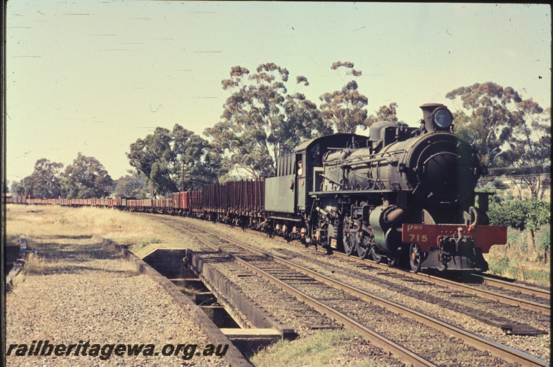 T04504
PMR class 715 steam locomotive at the head of a goods train, crossing the bridge over the Neerigen Brook, enroute to Bunbury, arriving at Armadale, SWR line, also shows the abandoned trackbed of the line to Fremantle veering away to the left (FA line)
