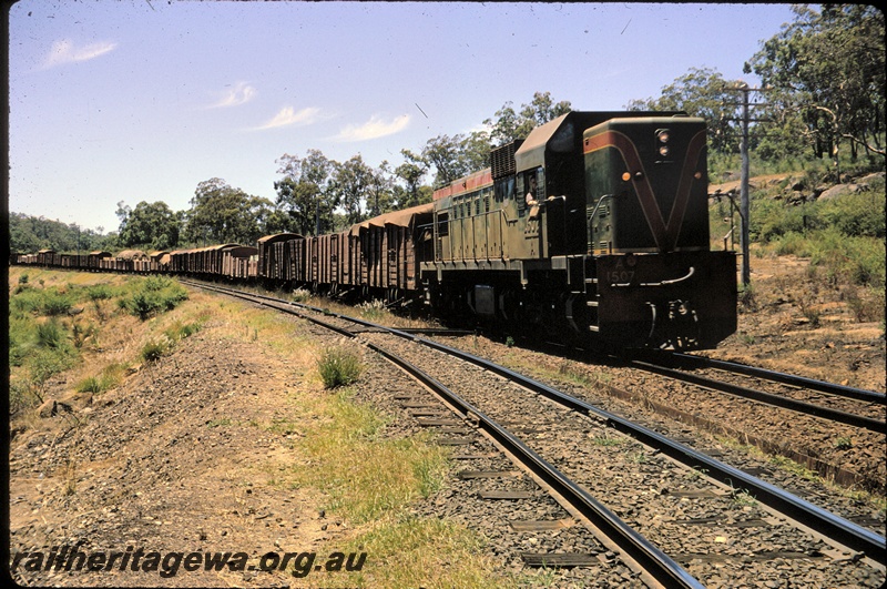 T04576
A class 1507 diesel locomotive with a goods train in the Darling Ranges, ER line.
