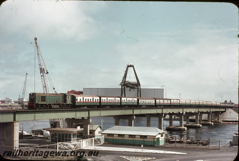 T04611
R class 1902 diesel locomotive with side chains, hauling a special passenger train over the Fremantle bridge enroute to Kwinana. See T4596 and T4609.
