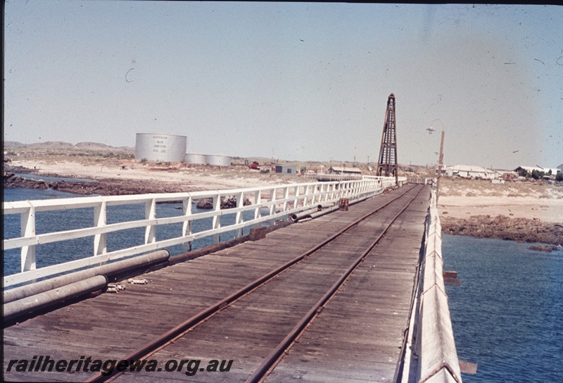 T04632
The Port Sampson jetty, looking towards the shore line with a crane on the jetty side. Fuel tank 'farm' in the background.
