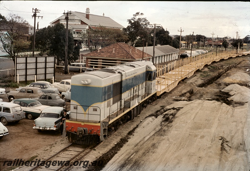 T04673
K class standard gauge diesel locomotive at the head of a rake of WF class standard gauge class flat top wagons at Midland. See T4671.
