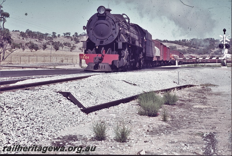 T04718
V class 1201 steam locomotive with a York bound goods train crossing the Northam - Spencers Brook road.
