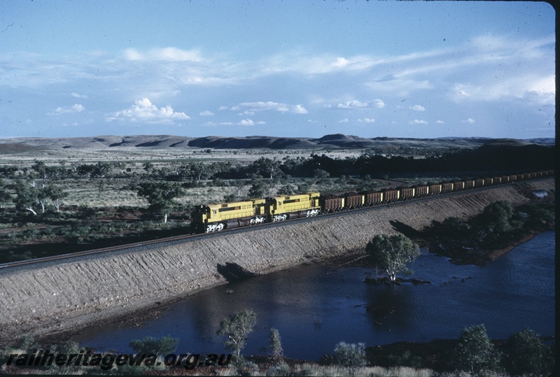 T04750
Cliffs Robe River (CRRIA) double headed M636 class haul a loaded ore train to Cape Lambert across the Harding Dam back water 
