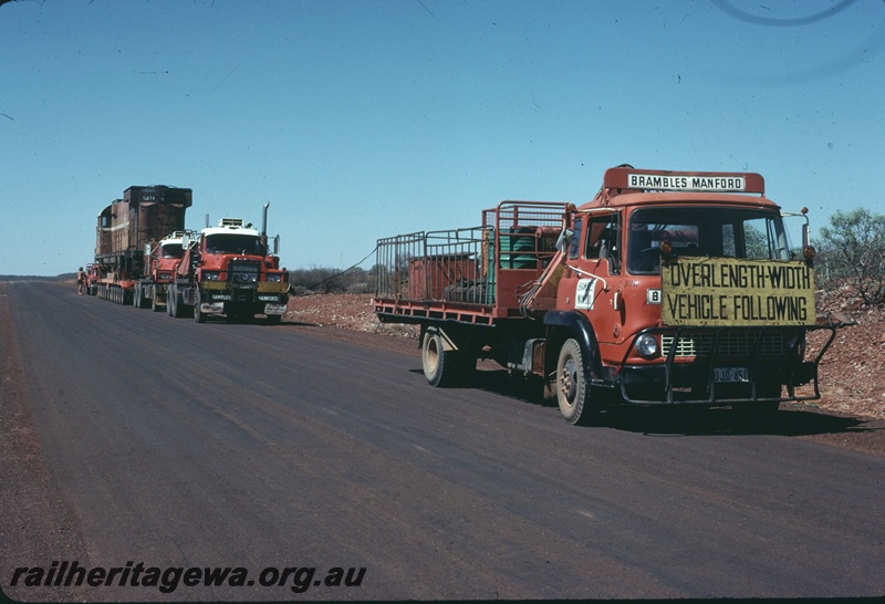 T04752
Mount Newman Mining M636 class 5474 on 96 wheel trailer being transported by road to Comeng WA Bassendean for rebuilding. Picture taken near Newman.
