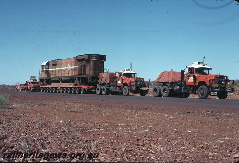 T04753
Mount Newman Mining M636 class 5474 on 96 wheel trailer being transported by road to Comeng WA Bassendean for rebuilding. Picture taken near Newman.

