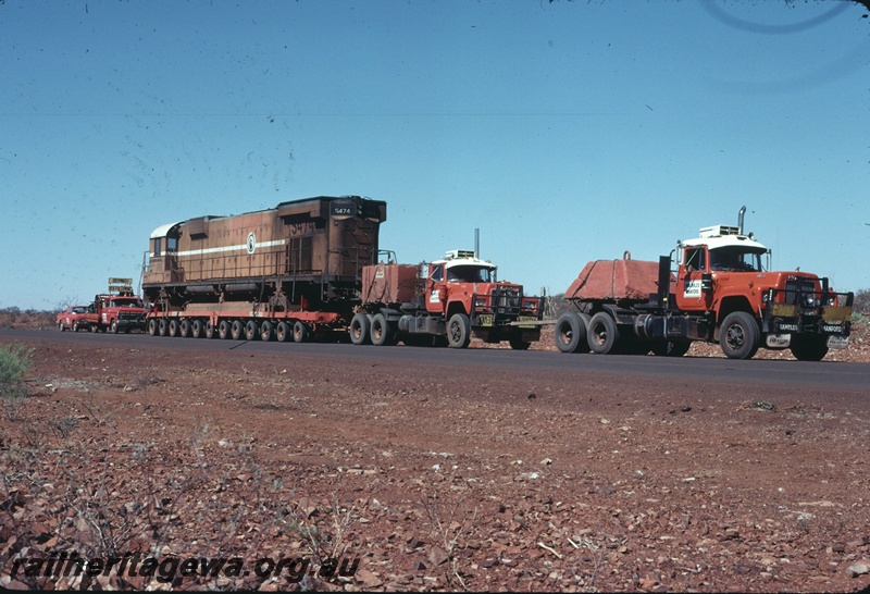 T04753
Mount Newman Mining M636 class 5474 on 96 wheel trailer being transported by road to Comeng WA Bassendean for rebuilding. Picture taken near Newman.
