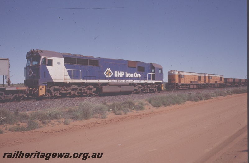 T04835
BHP Iron Ore (Goldsworthy Operations) GML 10 class (blue livery) hauling loaded iron ore train near Finucane Island crossing empty ore train hauled by 2 A class English Electric locomotives.
