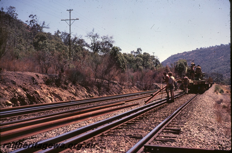 T04854
Rail carrying wagon, workers dropping rails, Avon Valley line, end view
