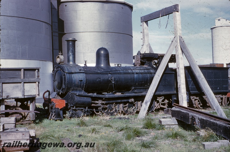 T04993
PWD steam loco 19 (ex WAGR G class 50, ex NAR NGA class 80), tanks, silos, scaffold, side tipping wagon mostly obscured, Bunbury, side view
