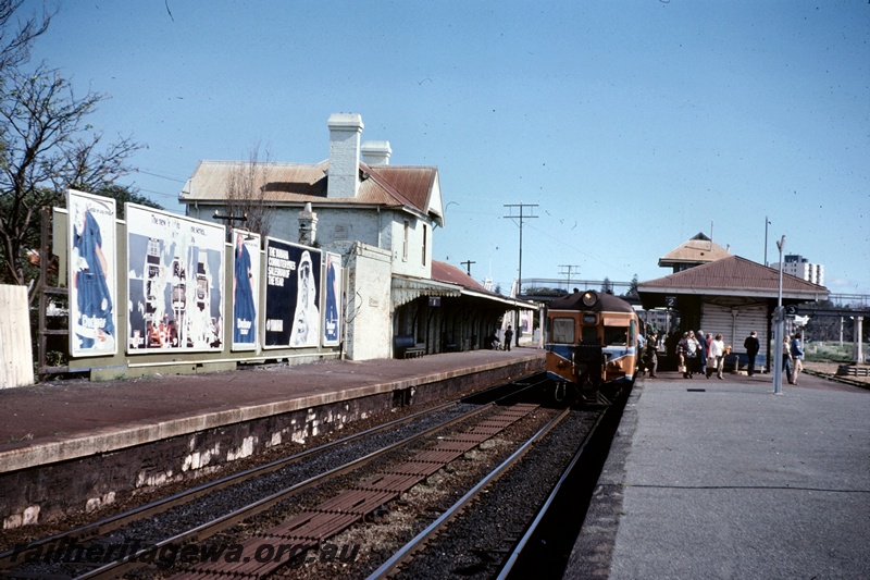 T05077
DMU passenger set, platforms, station buildings, pedestrian overpass, hoardings, passengers, rodding between tracks, signal box, Claremont station, ER line, day before Fremantle line closure
