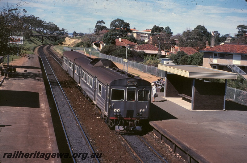 T05134
ADK class 688 heading two car DMU set bound for Fremantle, platforms, pedestrian overpass, station shelter, passenger, houses, West Leederville, ER line
