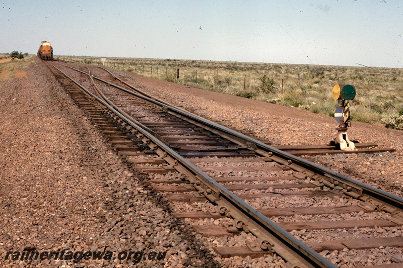 T05166
Goldsworthy Mining (GML) unidentified passing loop on the Goldsworthy railway showing point indicator and train in background. 
