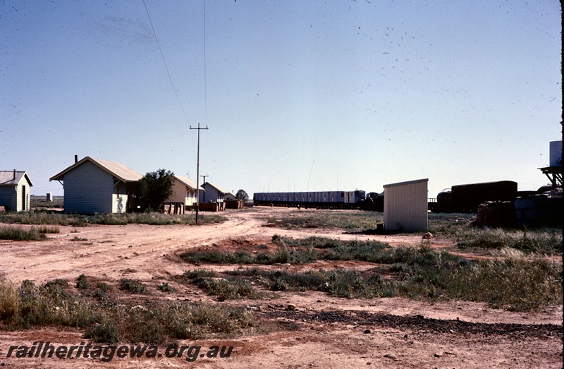 T05239
Huts on wheels with radio masts, tank wagon, van, water tank, buildings, outhouse, road, woodpile, Mundrabilla
