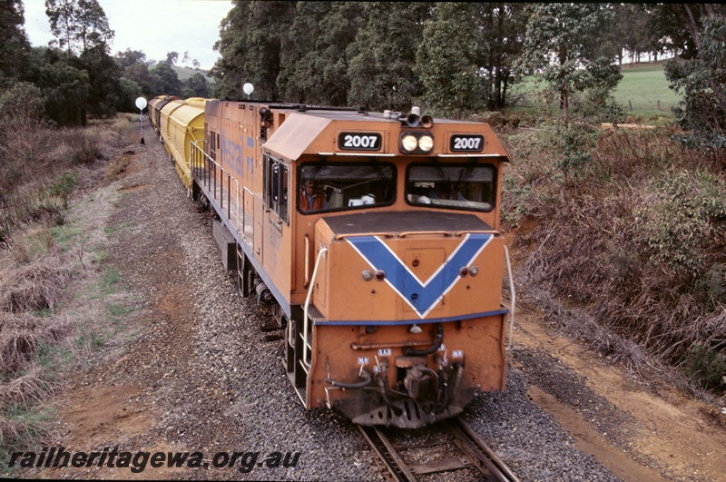 T05272
1 of 3 views of Westrail P class P2007 diesel loco in the orange livery with the blue stripe hauling a coal train made up with XY class hoppers. Seen here at Beela, BN line, mainly a head on view
