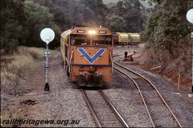 T05273
2 of 3 views of Westrail P class P2007 diesel loco in the orange livery with the blue stripe hauling a coal train made up with XY class hoppers, passing through Beela, BN line passing a searchlight signal. , head on view.
