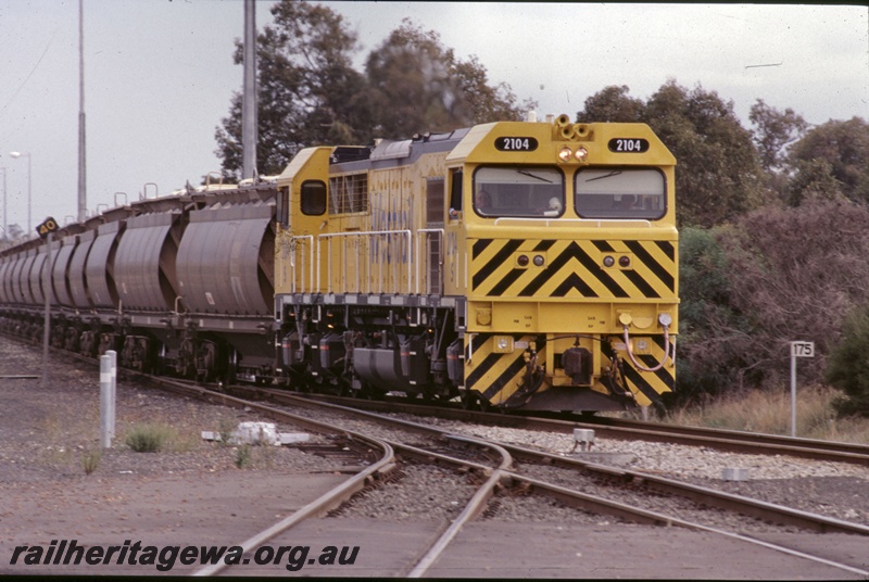 T05288
Westrail S class 2104 diesel loco in the yellow livery with the black chevrons on the front, on an alumina train of XF class wagons, Picton, SWR line, view along the train

