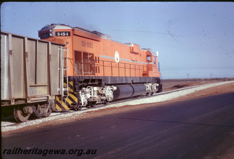 T05310
Mount Newman Mining diesel loco 5454, on iron ore train, heading away from camera, Port Hedland, end and side view
