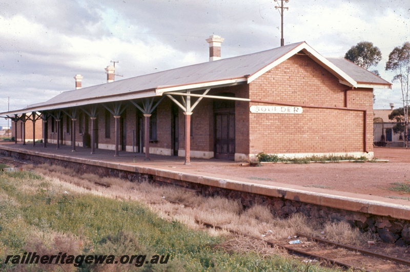 T05325
Station buildings, platform, overgrown track, Boulder, B line, view from track level
