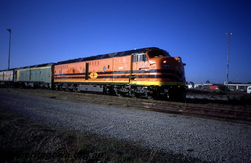 T05399
Australian Railroad Group Australia Western Railroad CLP class 13 in black and orange livery, and ALF class 22 in green and gold livery, industrial buildings, tracks, side and front view
