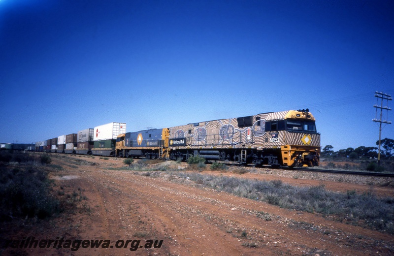 T05410
National Rail NR class loco 52 in indigenous livery, and NR class in blue and gold livery, double heading double stacked intermodal freight train, arriving Parkeston, TAR line, side and front view
