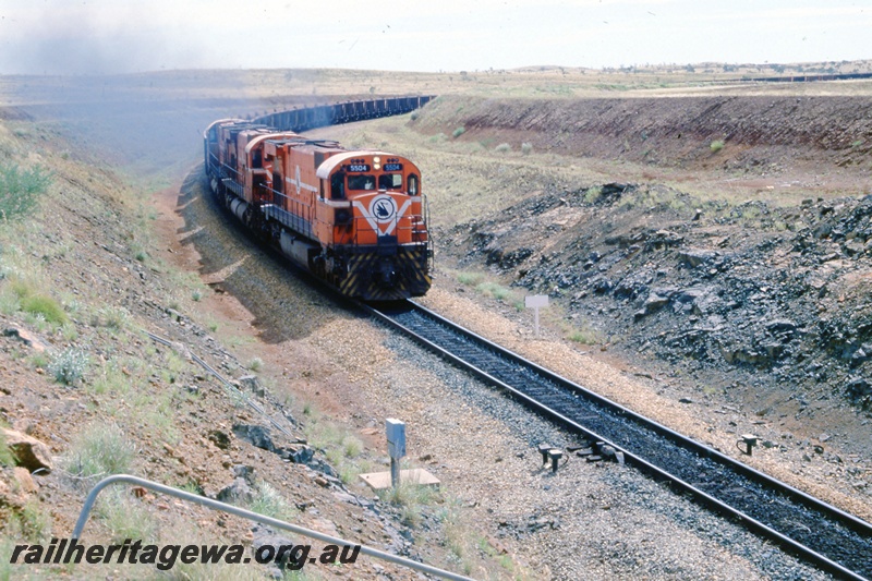T05530
Mt Newman Mining's Comeng MLW 5504 leads a loaded iron ore train to Port Hedland.
