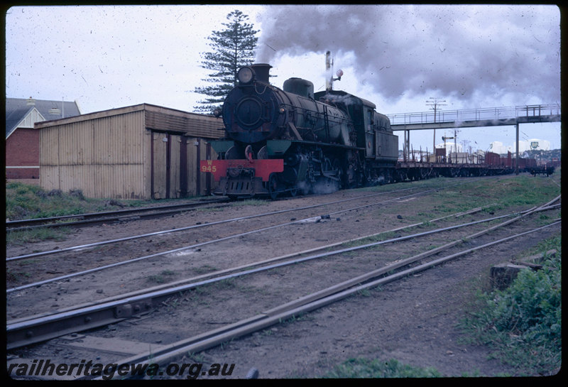 T06403
W Class 945, departing Bunbury, goods train, gangers sheds, footbridge
