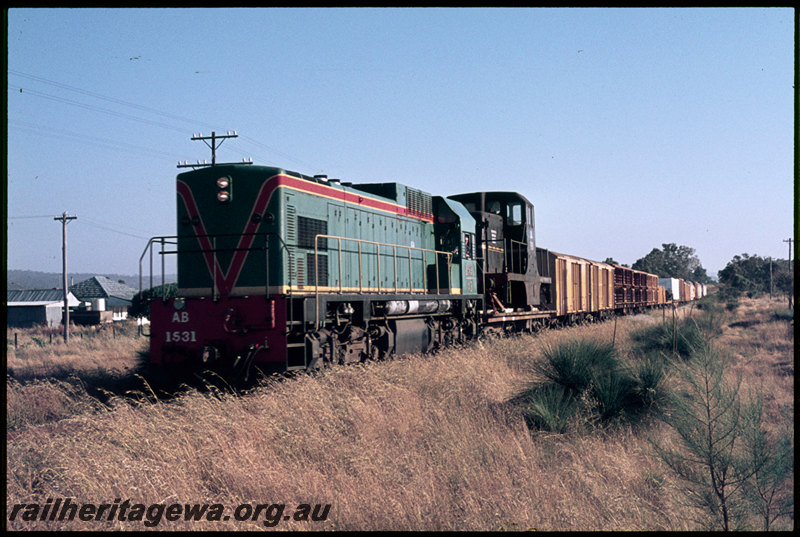 T06867
AB Class 1531, Geraldton Freighter, ex-NSWGR 79 Class 7920 loaded on QCE Class 23594 flat wagon in consist, 79 Class bound for Geraldton to be shipped to British Phosphate Commissioners on Christmas Island, near Millendon, MR line
