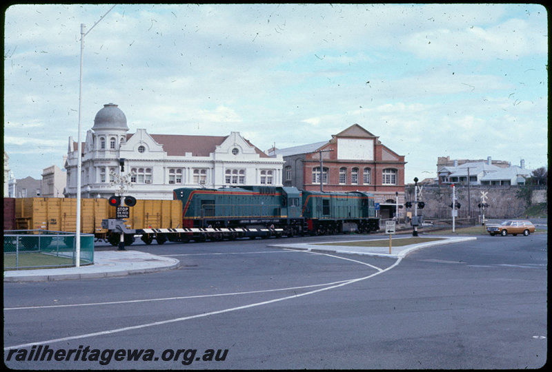 T06959
RA Class 1916, Down goods train, AB Class 1531 dead attached, Fremantle, Phillimore Street level crossing, boomgates, Round House, FA line
