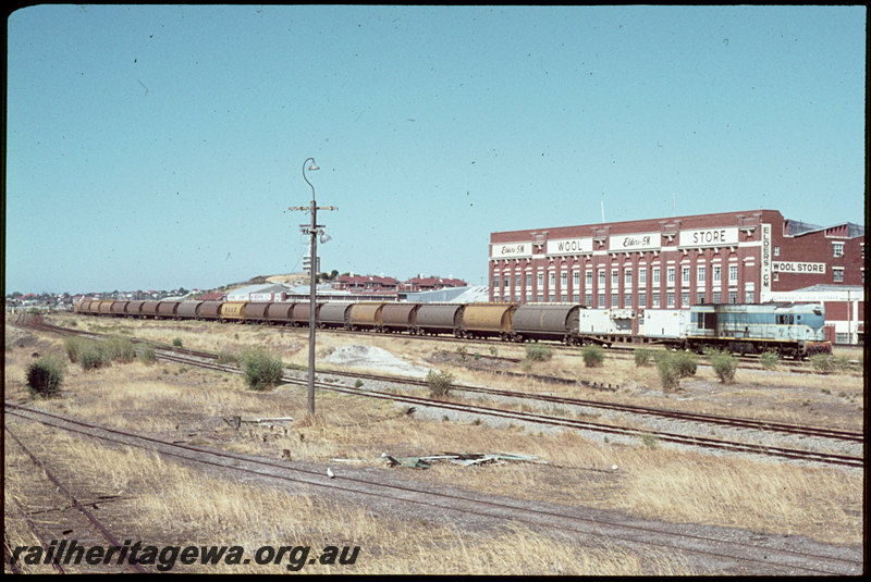 T07056
K Class 210, Up goods train, Fremantle, note yellow wheat ear logo on first WWA Class grain wagon, Elders Wool Store, ER line
