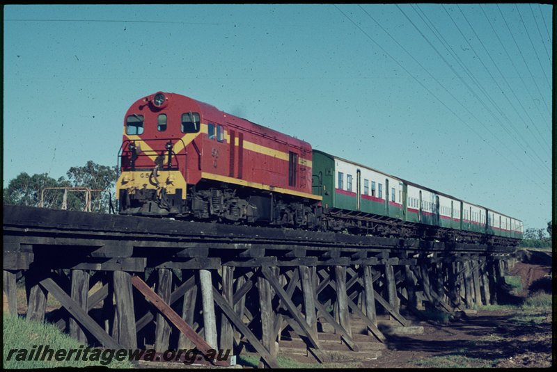 T07064
G Class 50, International Orange livery, Down suburban passenger service, crossing Canning River Bridge, timber trestle, between Stokely and Gosnells, SWR line
