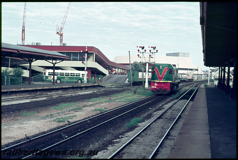 T07110
DA Class 1572, light engine, A Class 1513, pink undercoat, departing on Up suburban passenger service in background, City Station, Perth, semaphore bracket signal, p;atform, canopy, MTT Leyland Tiger Cub, Wellington Street Bus Station, Perth Entertainment Centre, ER line
