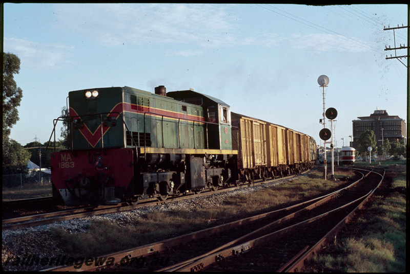 T07283
MA Class 1863, Down transfer goods, East Perth, passing Perth Terminal, The Royal Silver Jubilee Exhibition train in dock platform, searchlight signals, Westrail Centre, ER line
