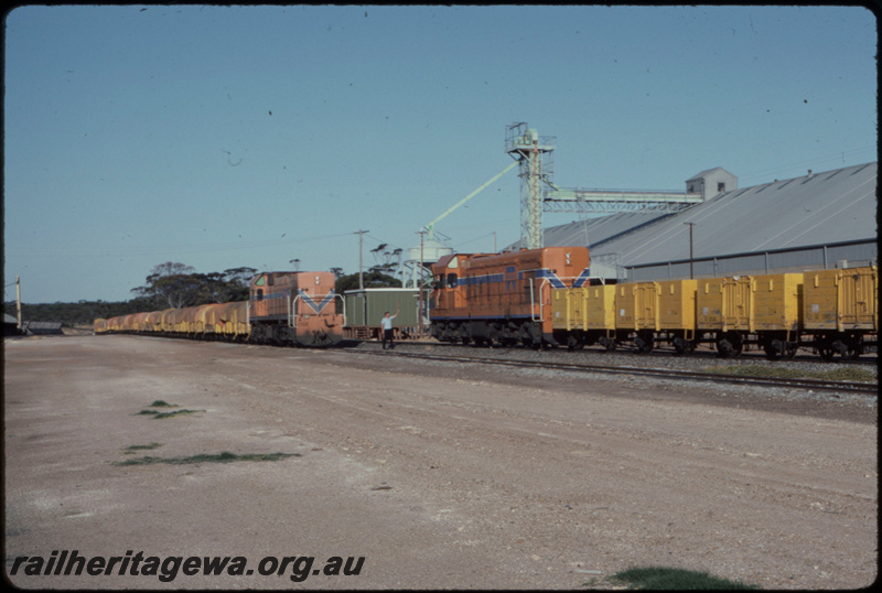 T07674
A Class 1512, Up loaded grain train, A Class 1506, Down empty grain train, staff exchange, safeworking shed, Kukerin, CBH bin, WLG line

